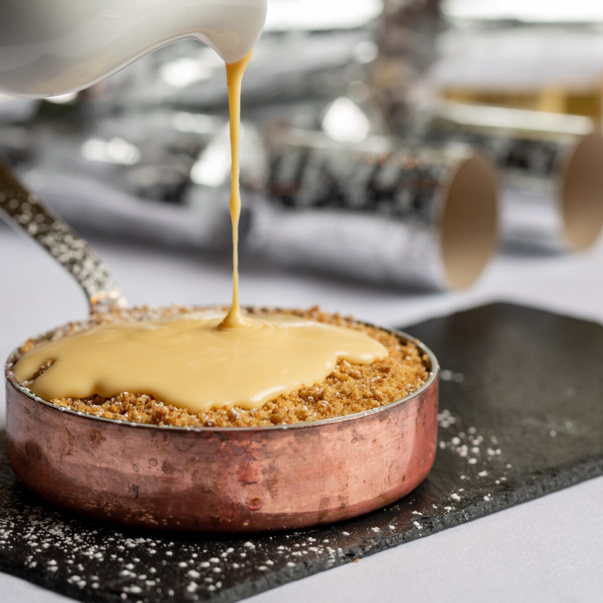 Custard being poured on a dessert.
