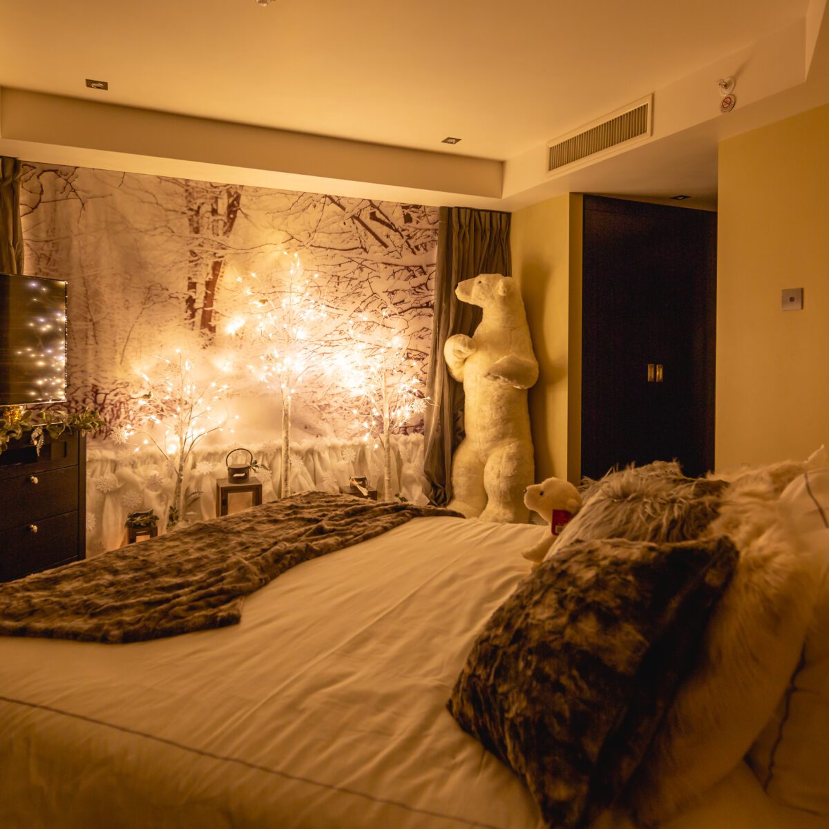 A Christmas-themed hotel room with trees, lights and a view out onto London